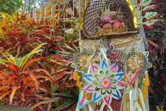 Altar decorated with colorful palm frond ornaments and piled with prayer offerings for Kuningan Day