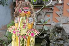Altar decorated with colorful palm frond ornaments and piled with prayer offerings for Kuningan Day