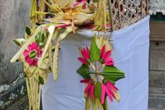 Altar decorated with colorful palm frond ornaments and piled with prayer offerings for Kuningan Day