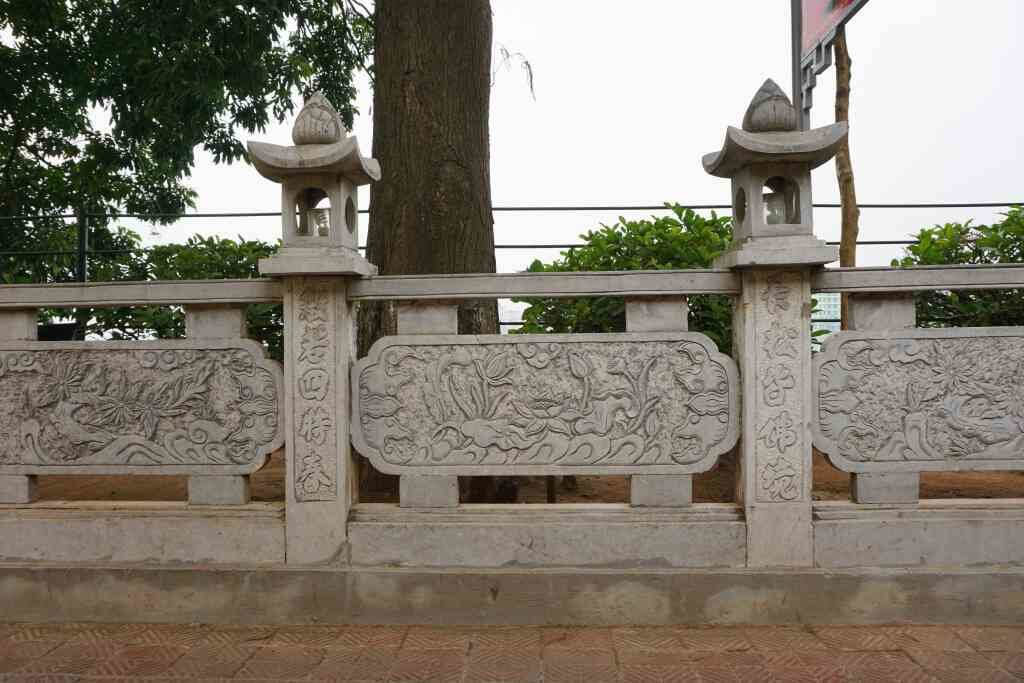 Carved stone panels, each a different scene, line the walkway
