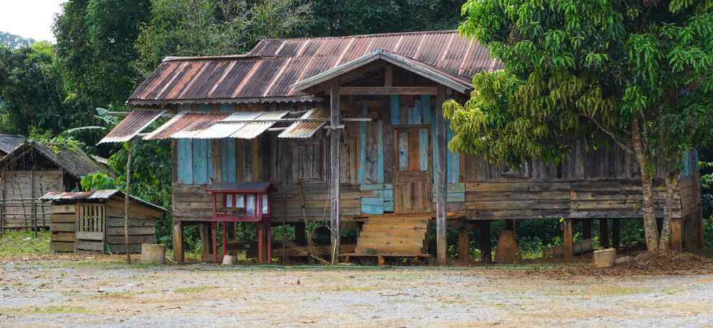 A traditional wooden stilt house, "improved" with a corrugated metal roof