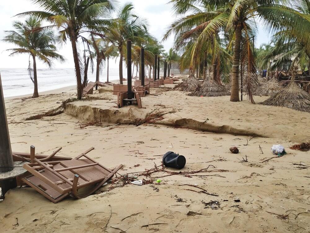 Battered palm trees and heavy erosion on My Khe Beach