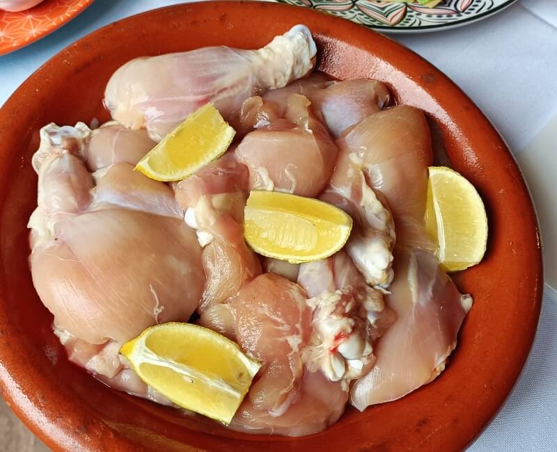 Marinated chicken with lemon wedges