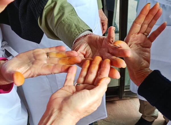 Class chefs comparing saffron-stained fingers