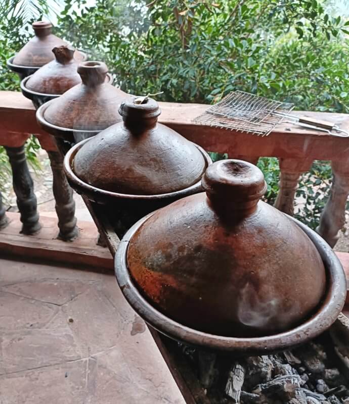 Covered tajines simmering over the charcoal fire